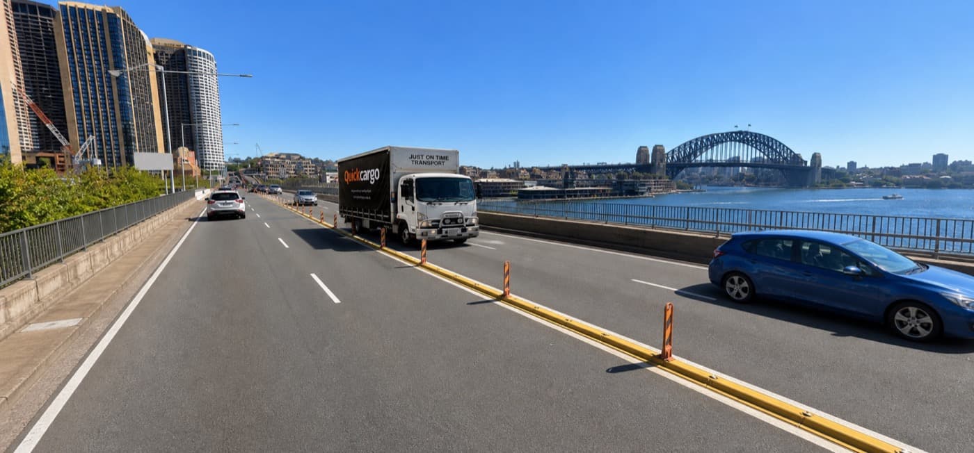 Quick Cargo branded truck on the Cahill Expressway with the Sydney Harbour Bridge behind